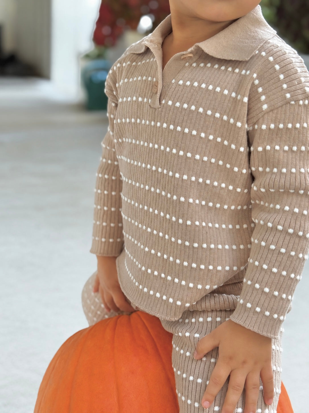 Close-up of an Atelier rib-knit polo worn with matching pants