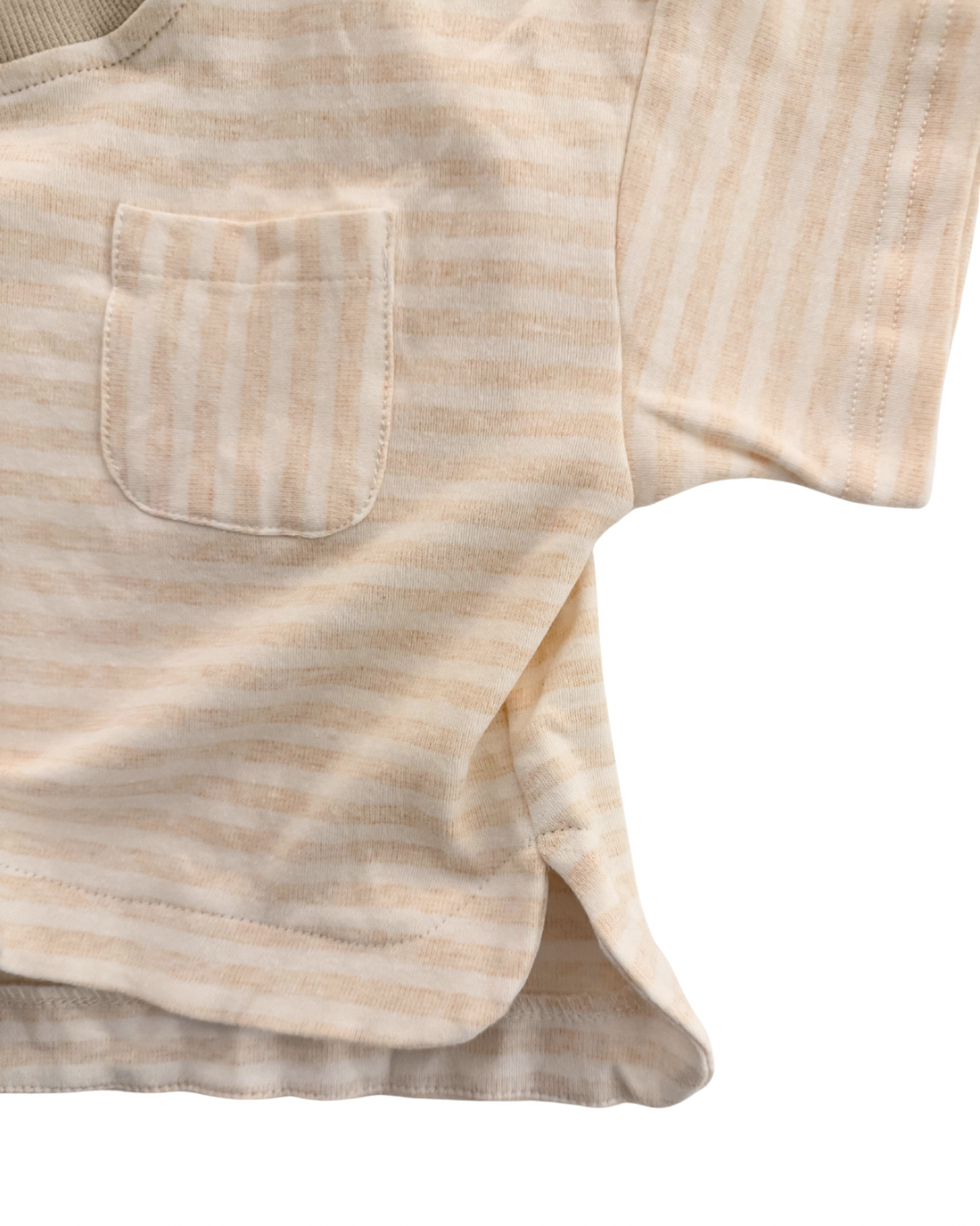 Close-up of a beige striped shirt with a pocket on a white background
