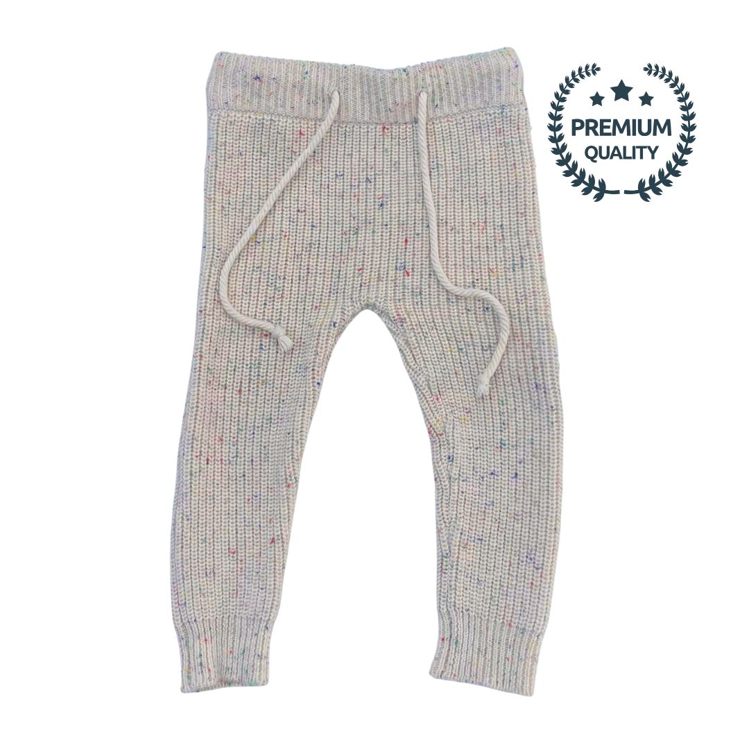 Flat lay of the Confetti Legging, a jogger-style pant featuring a drawstring waist and ribbed cuffs. The soft, premium cotton fabric with colorful specks on a neutral beige base is clearly visible.