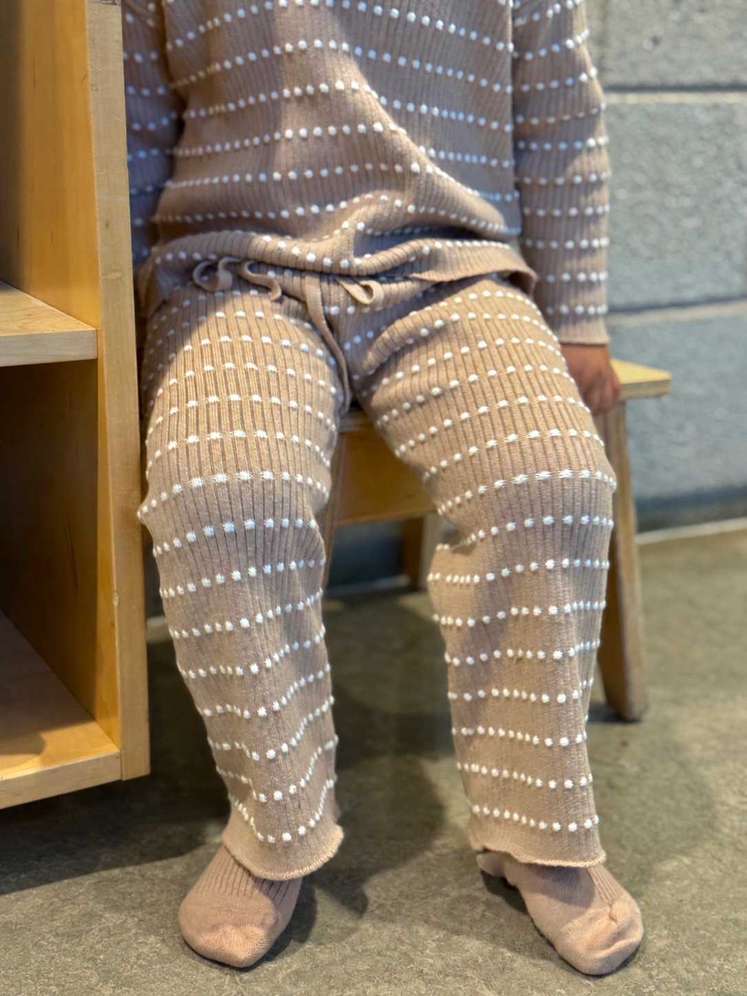Child seated in Atelier knit pants
