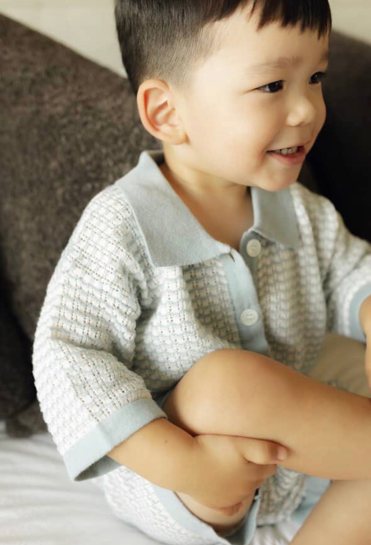 Child wearing a light blue knit shirt with a textured pattern