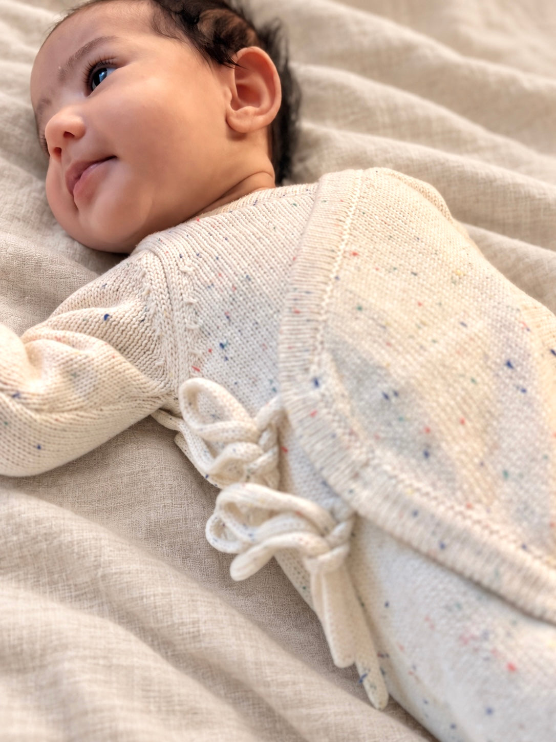 Baby wearing a cream Confetti Tie Romper with front ties