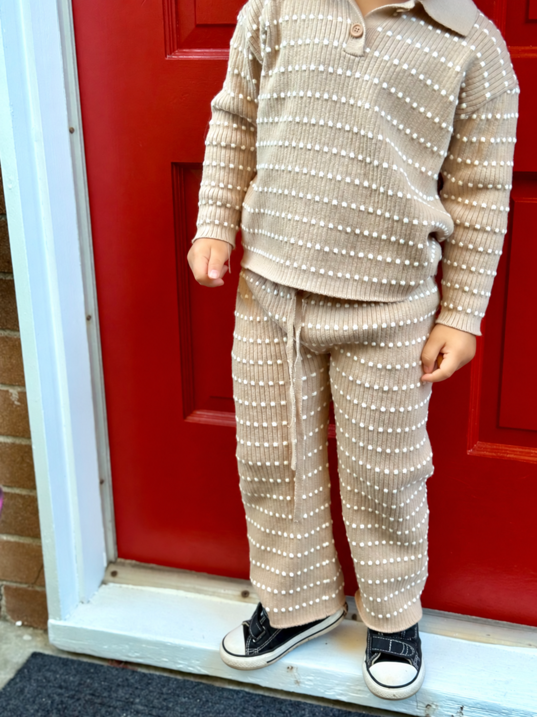 Child standing in an Atelier knit polo and pants set
